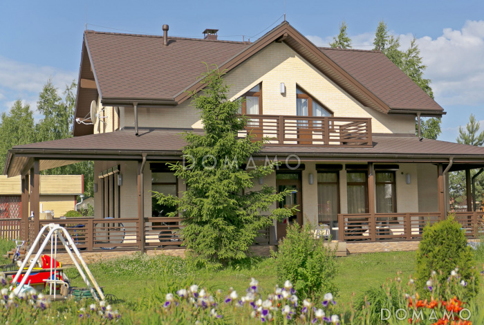 Проект каркасного дома с угловой террасой и просторныб балконом на мансардном этаже