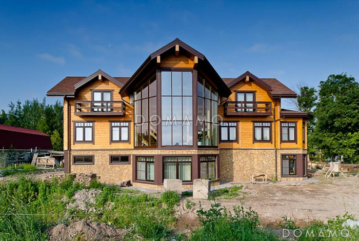 Проект стильного дома из клееного бруса с обширным остеклением и вторым светом